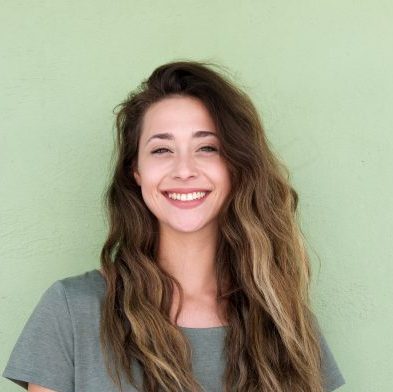 Portrait,Of,Smiling,Young,Woman,Against,Green,Background